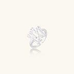 Sculptural sterling silver ring with organic branch design and textured surfaces on cream background