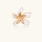 Gold-plated sculptural ring featuring white enamel petals forming an oversized lily bloom on adjustable band