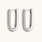 Close-up of platinum-plated sterling silver huggie hoops with pavé crystal setting on white background.
