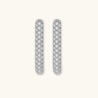 Close-up of platinum-plated sterling silver huggie hoops with pavé crystal setting on white background.